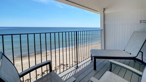 A balcony with a view of the beach and ocean.