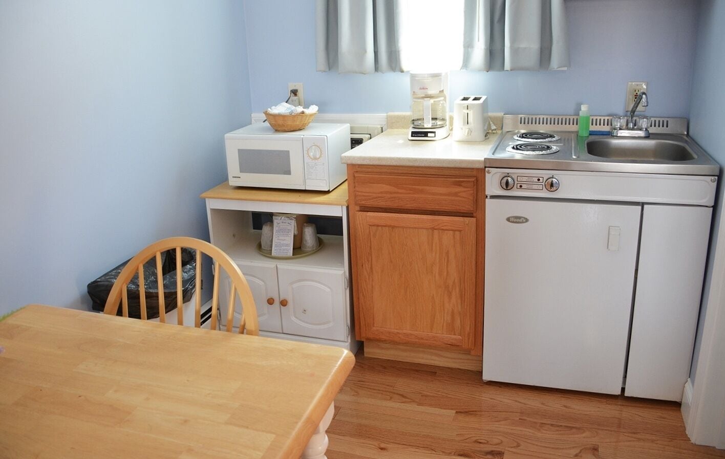 A compact kitchenette with a microwave, toaster, and sink.