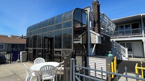 Ein modernes Gebäude mit Glasfassade, einer Treppe, die zu einem Balkon führt, und einem verschlossenen Eingang.