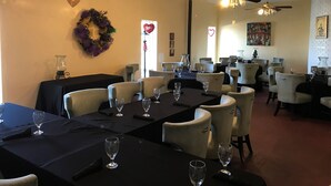 A restaurant with multiple tables, chairs, and ceiling fans. - Pascagoula Extended Stay (Pascagoula)
