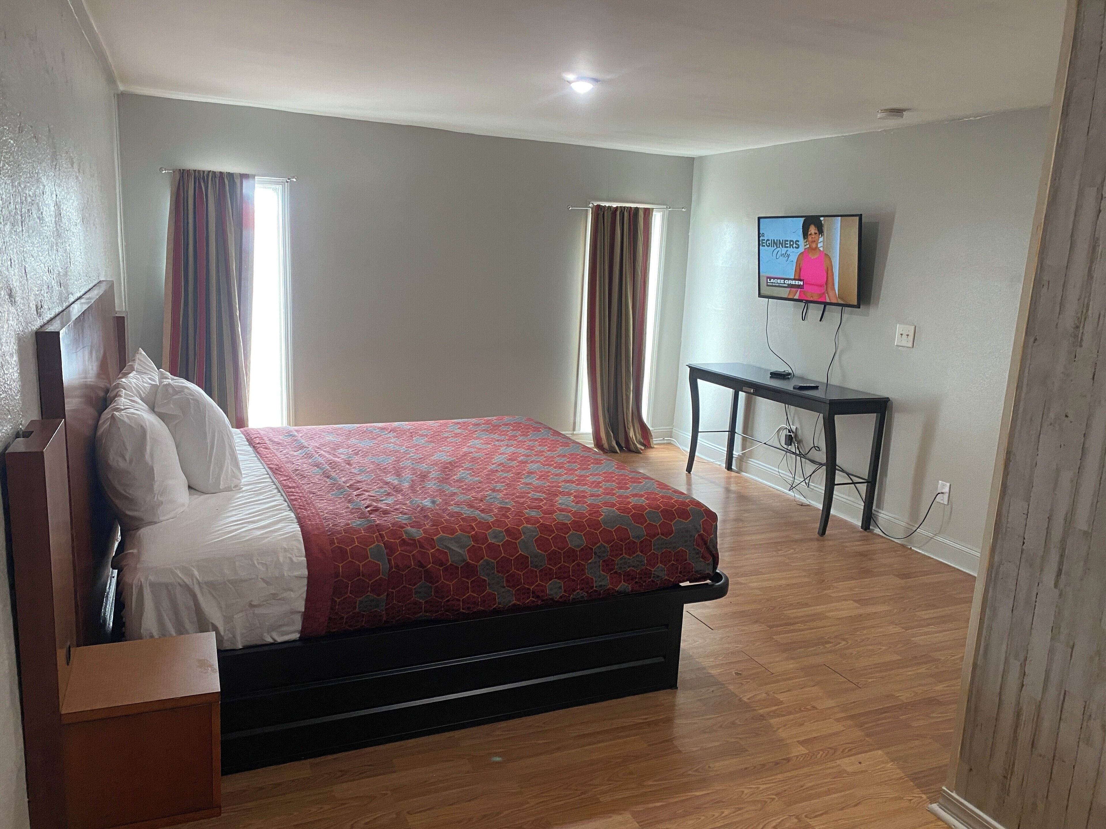 Une chambre à coucher avec un lit, une télévision et un bureau.
