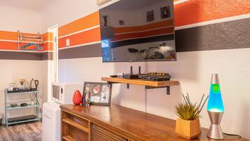 Una cocina moderna con encimera de madera, una lámpara de lava y una pequeña planta en maceta.