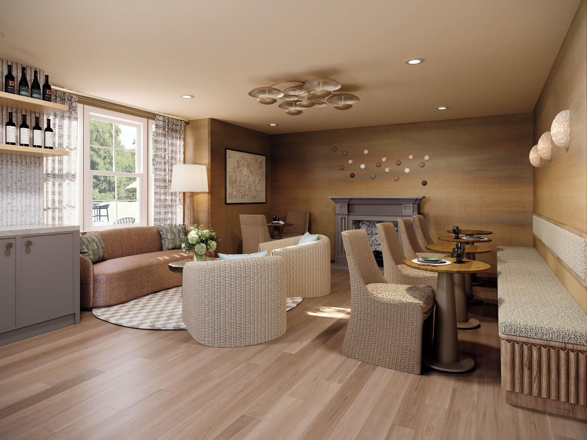 A spacious living area with a sofa, wicker chairs, a dining table, and a fireplace.