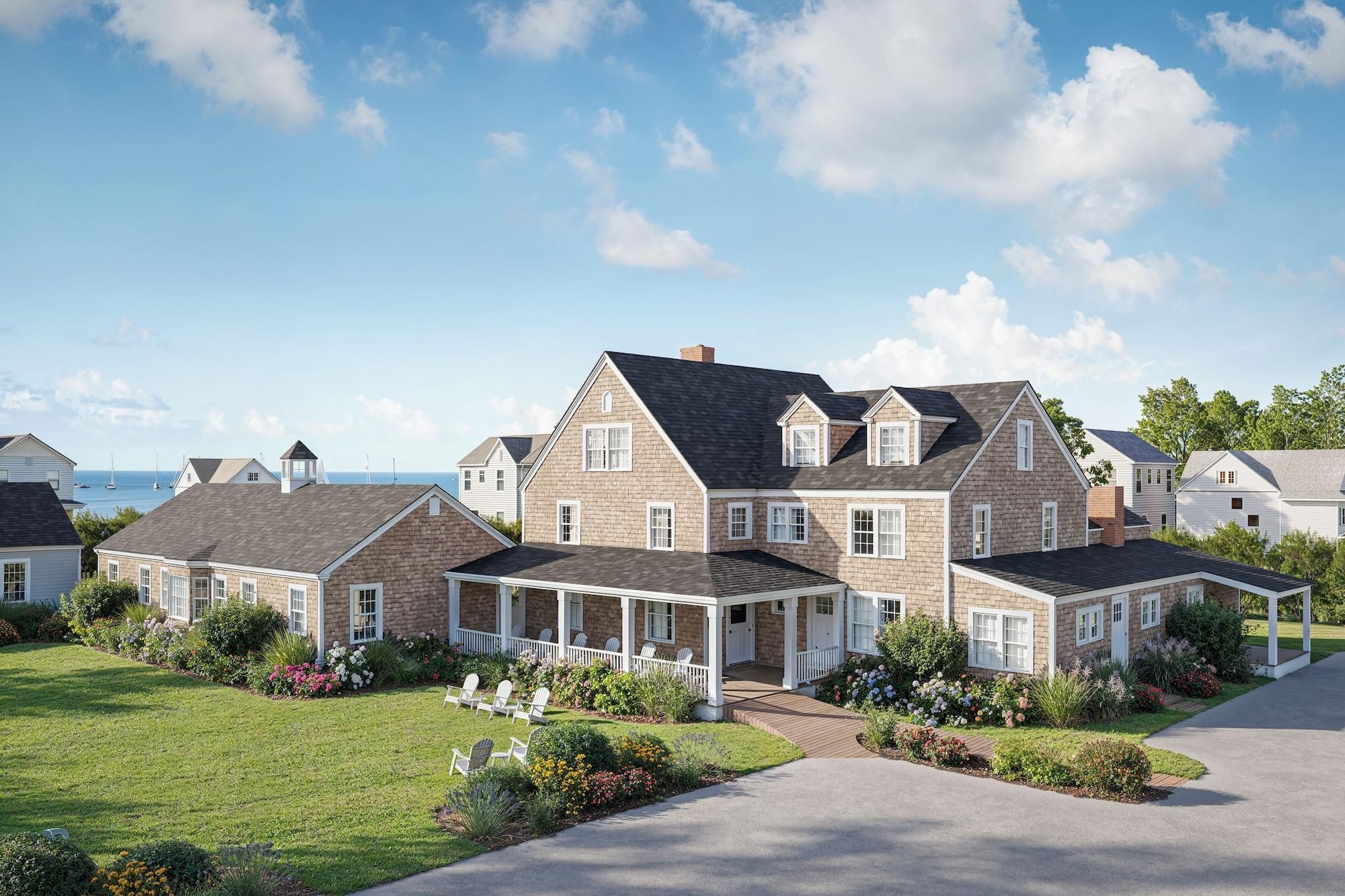 Une grande maison à deux étages, dotée d’un porche abrité et d’une pelouse bien entretenue.