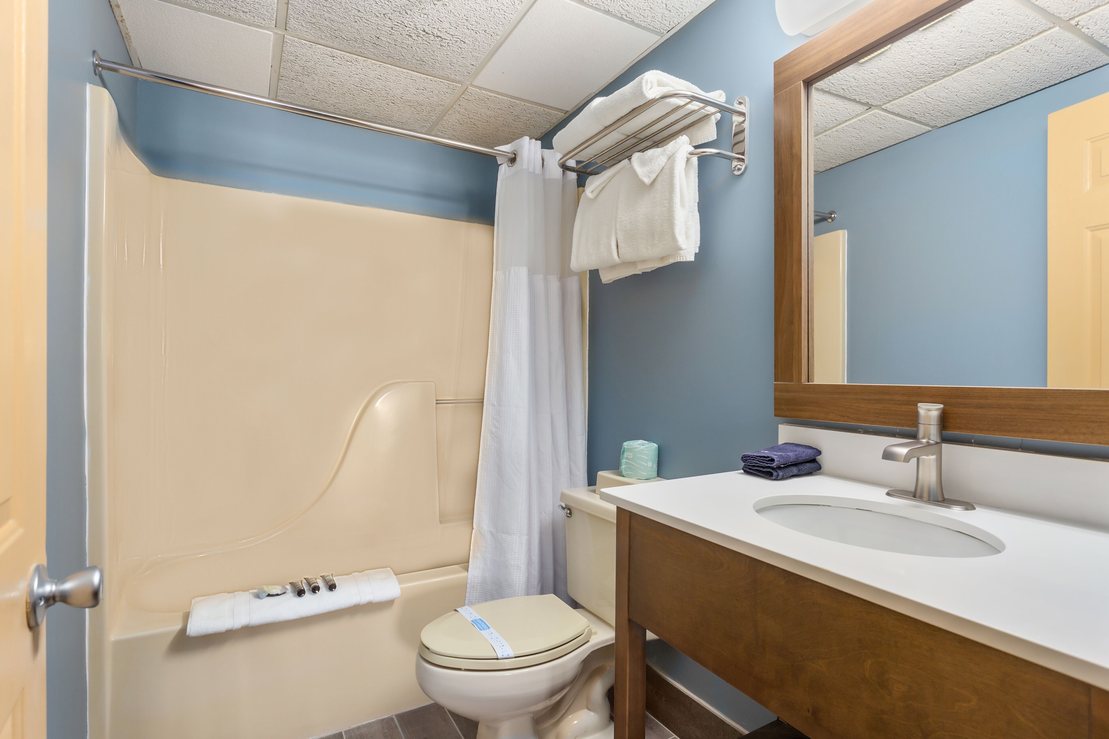 A bathroom with a bathtub, toilet, sink, and a mirror.