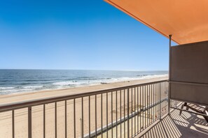 Een balkon met uitzicht op het strand en de oceaan.