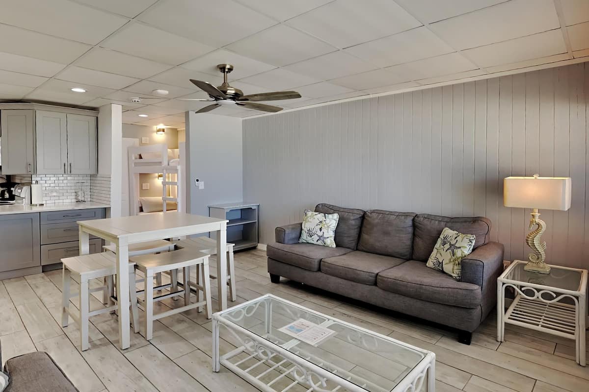A modern living room with a sofa, coffee table, and dining area.