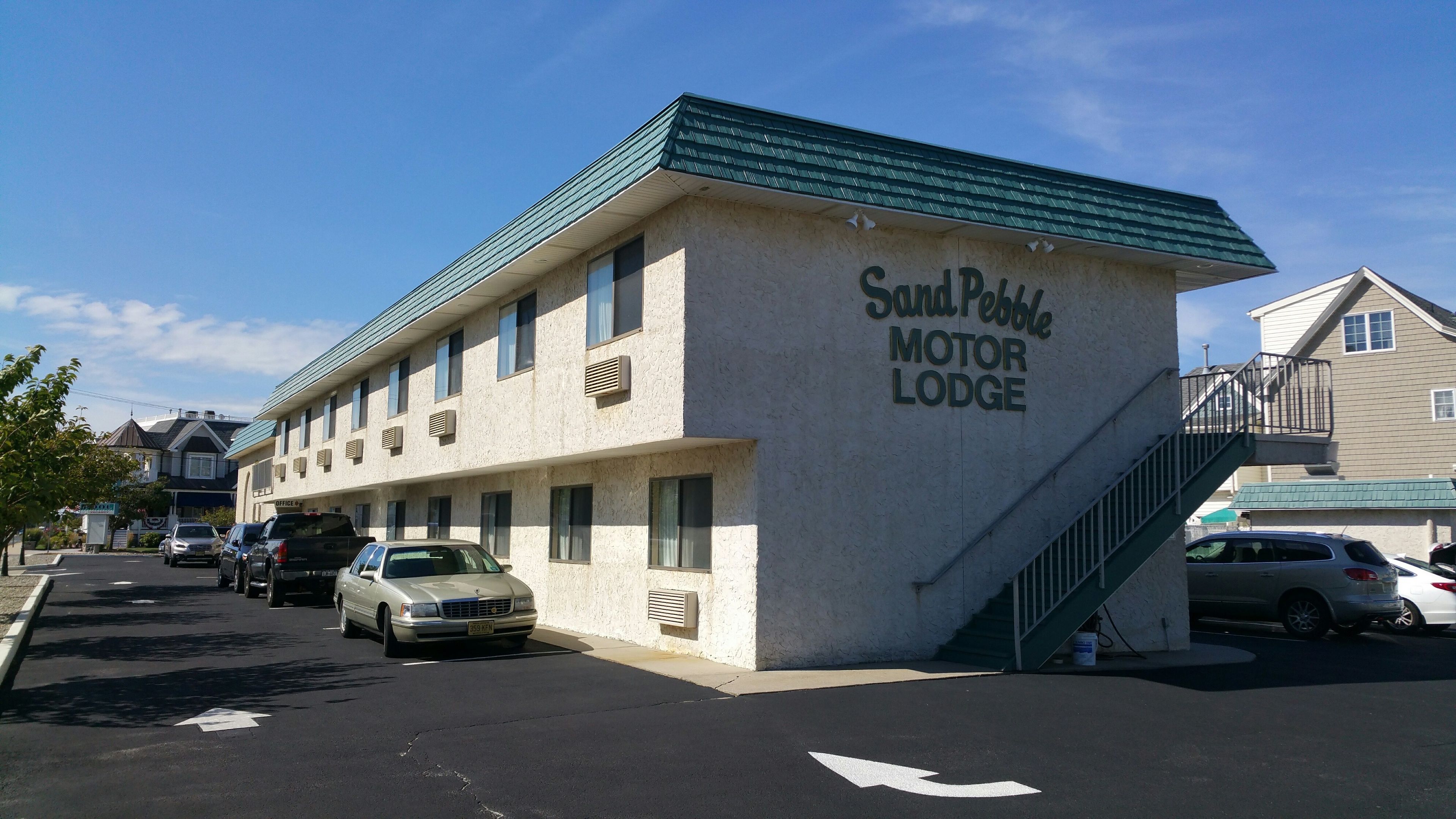 A building labeled "Sand Pebble Motor Lodge" with a parking lot in front.
