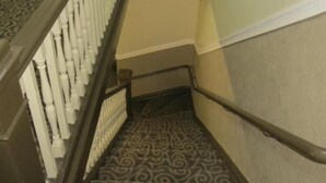 A carpeted staircase with a patterned design, a handrail, and a white balustrade. - Perramont Hotel (San Francisco)