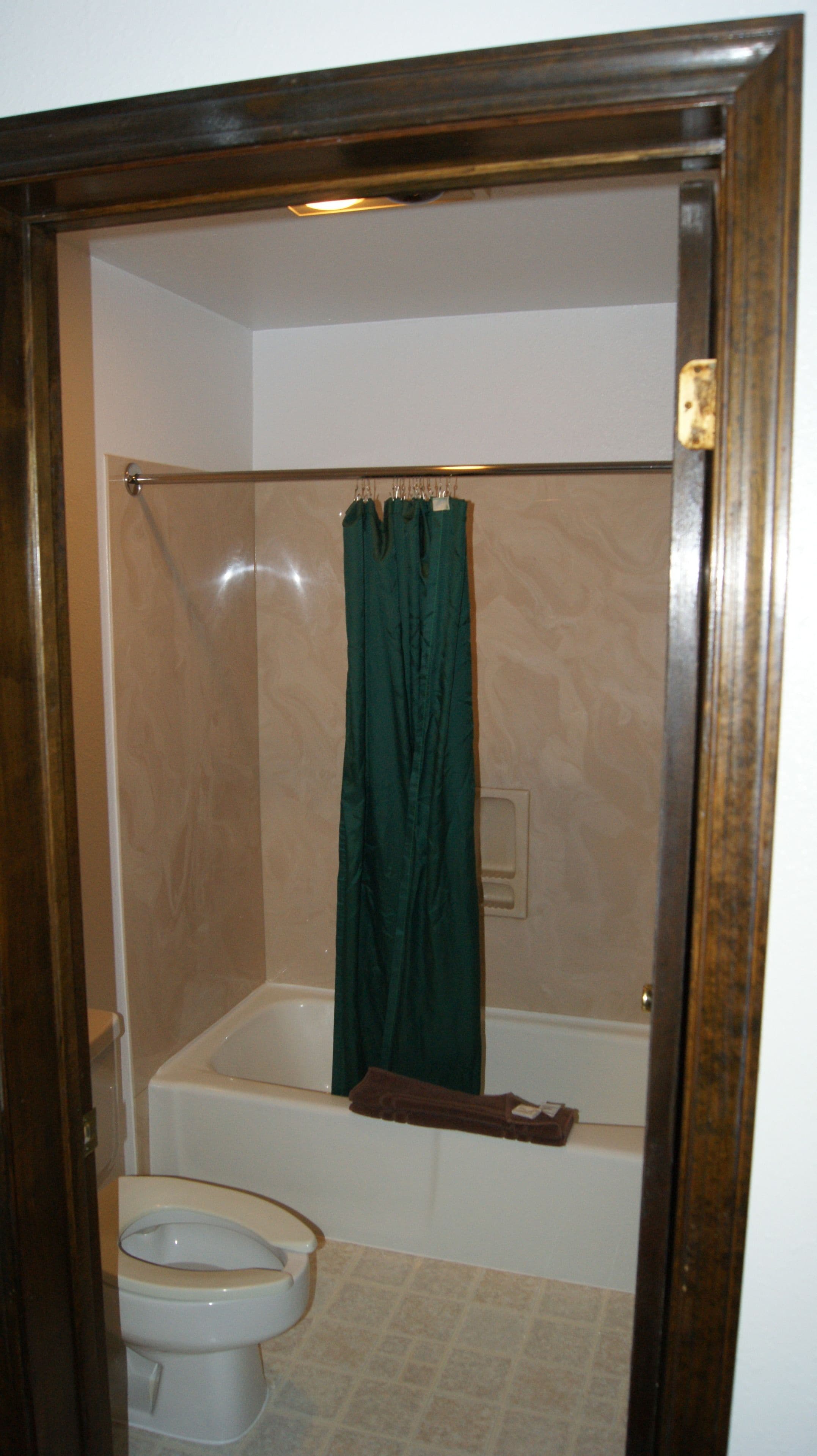 A bathroom with a bathtub, a toilet, and a shower curtain.