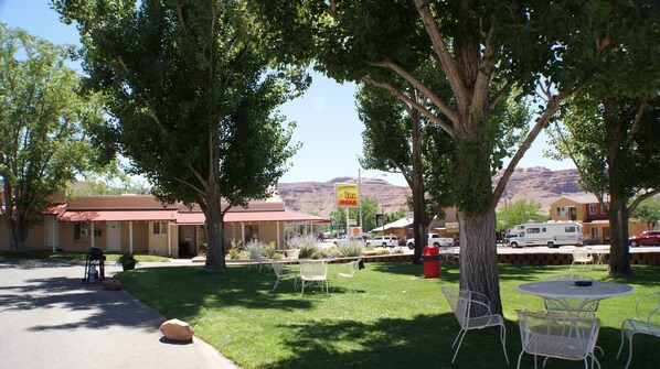 A motel with outdoor seating and a mountain view.