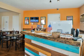 A reception desk with a sign reading "OUT GOING MAIL," a whiteboard, and a flag. - Adventure Inn & Motel (Moab)