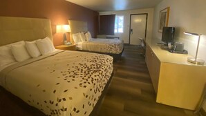A hotel room with two beds, a desk, a TV, and a window. - Adventure Inn & Motel (Moab)