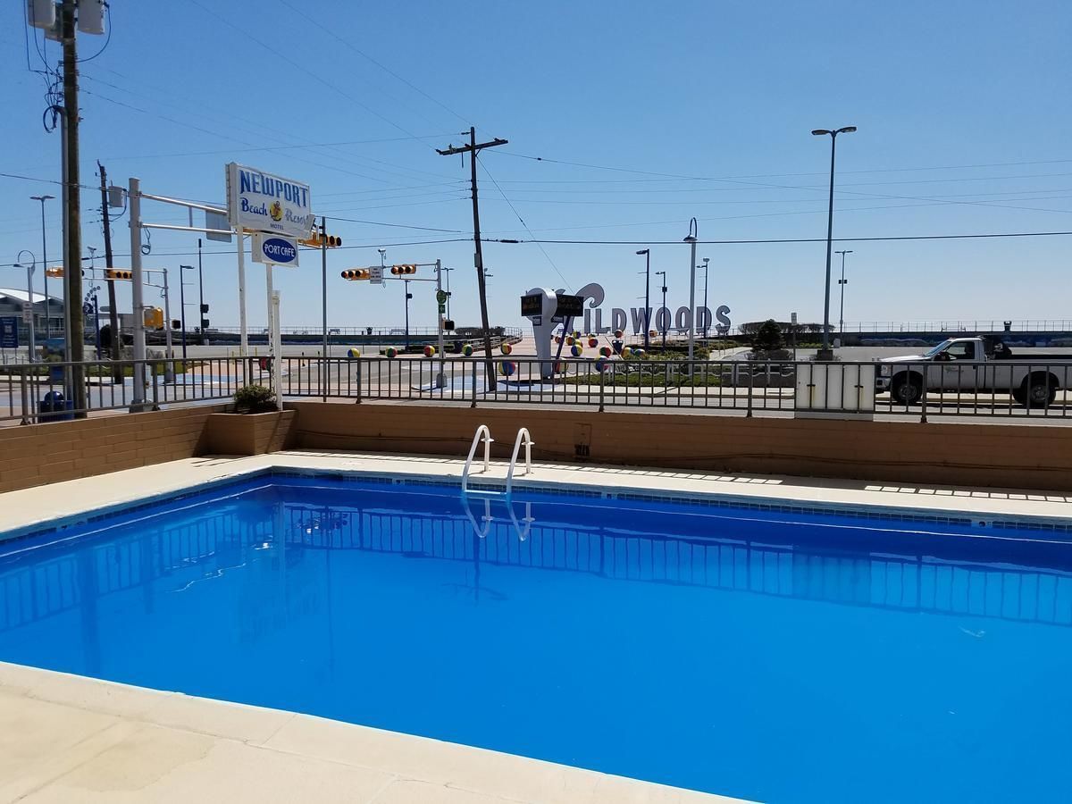 A swimming pool with a clear view of Newport Beach and the Wildwoods sign in the background.