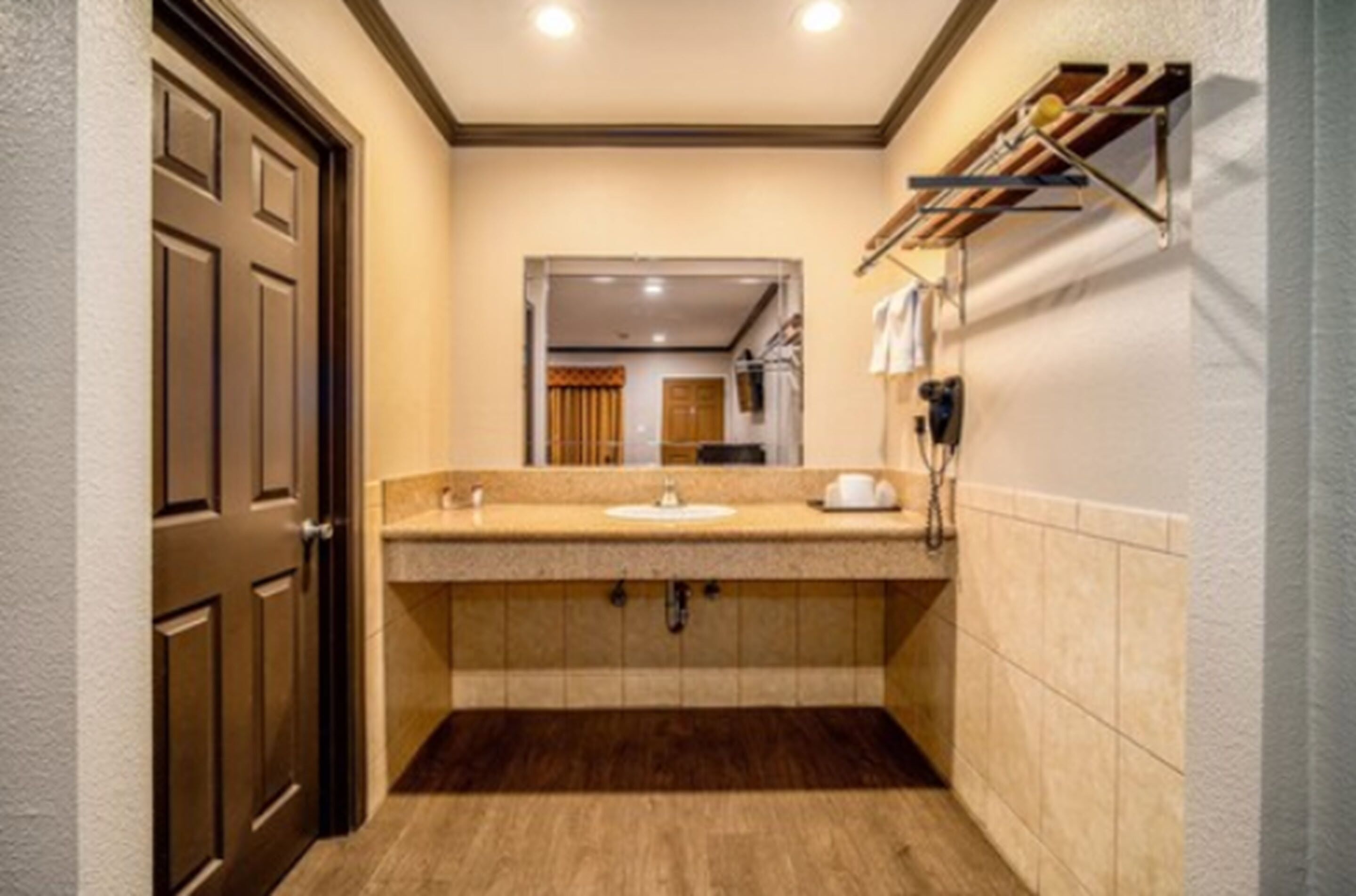 A bathroom with a double sink, a mirror, and a towel rack.