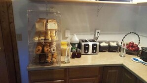 Un comptoir de cuisine avec un présentoir à pain, un grille-pain et divers condiments.