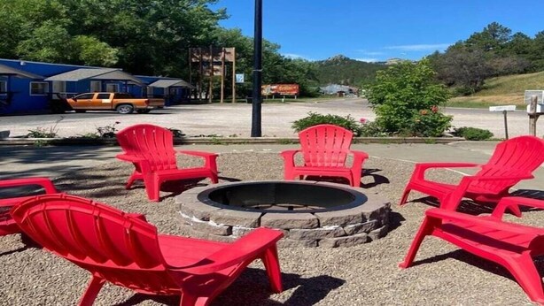 Un foyer avec des chaises rouges, un drapeau et un bâtiment en arrière-plan.