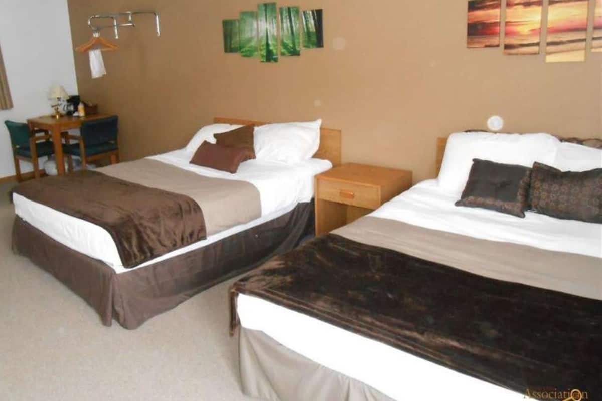Una habitación de hotel con dos camas, un escritorio y una silla.