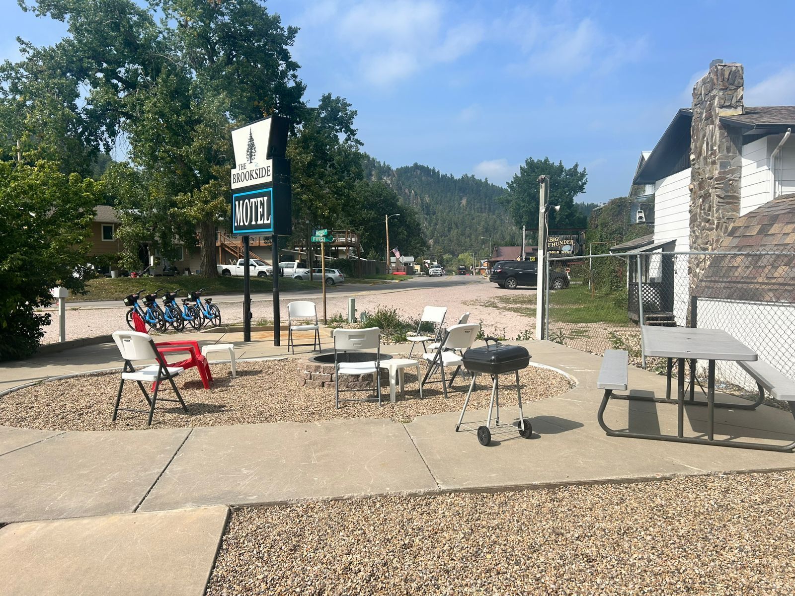 Un motel con mesas al aire libre y un cartel que indica un restaurante cercano.