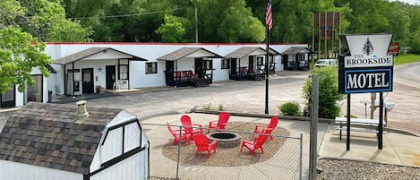 A motel with multiple cabins, outdoor seating, and a fire pit.