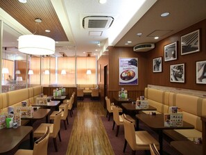 A restaurant with booths and tables, wooden flooring, and ceiling lights. - Jr-east Hotel Mets Komagome (Tokyo)