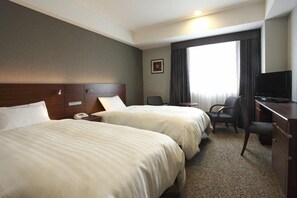 A hotel room with two beds, a desk, a chair, a TV, and a window with curtains. - Jr-east Hotel Mets Komagome (Tokyo)