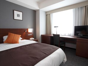 A hotel room with a large bed, a desk with a chair, a television, and a bedside table with a lamp. - Jr-east Hotel Mets Komagome (Tokyo)