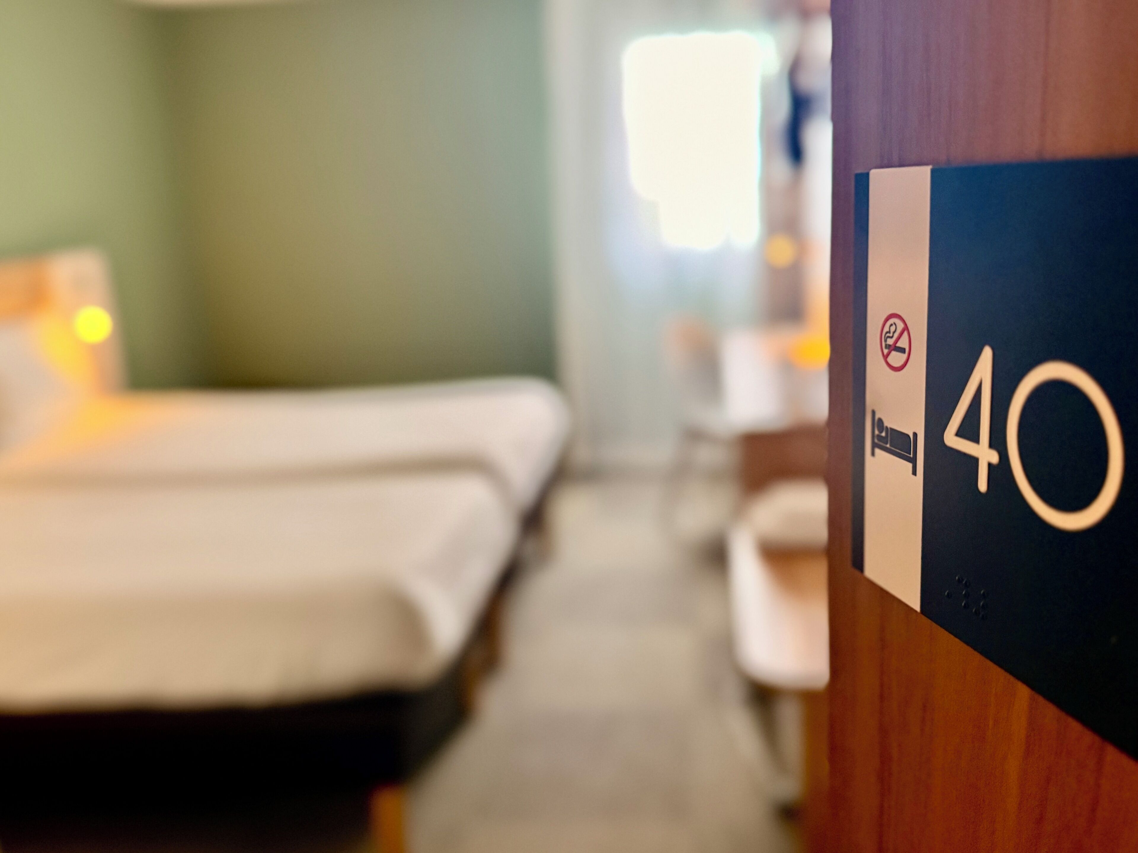 Une chambre d’hôtel avec deux lits, un bureau et une fenêtre.