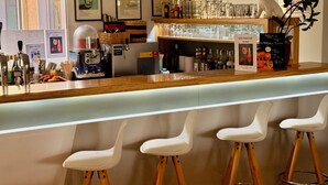 Een bar met krukken, een toonbank en diverse baraccessoires.