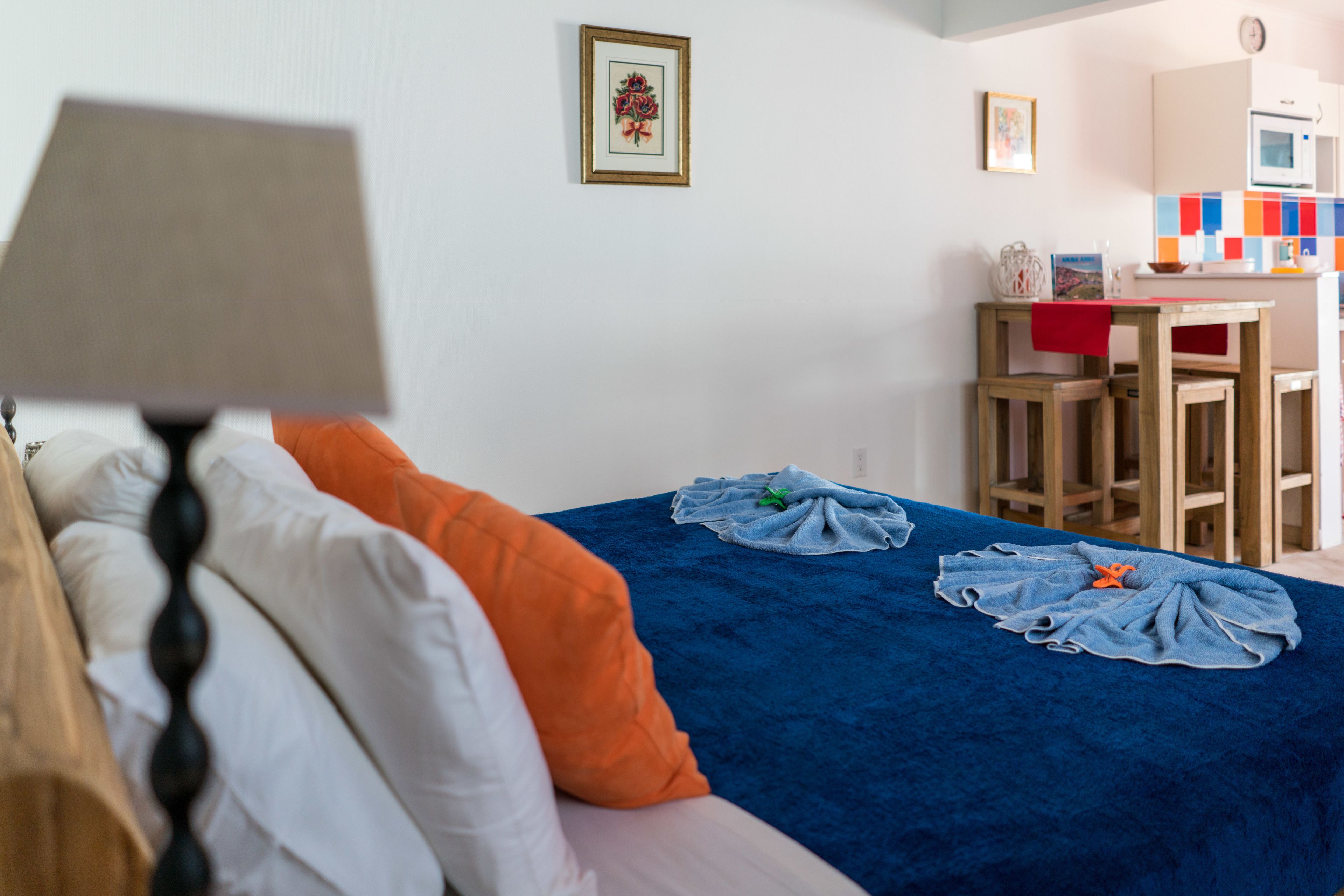 A bedroom with a bed, pillows, a blue blanket, and a wooden headboard.