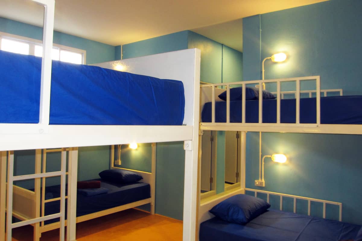 A bunk bed room with two beds, each with a pillow and a blanket.