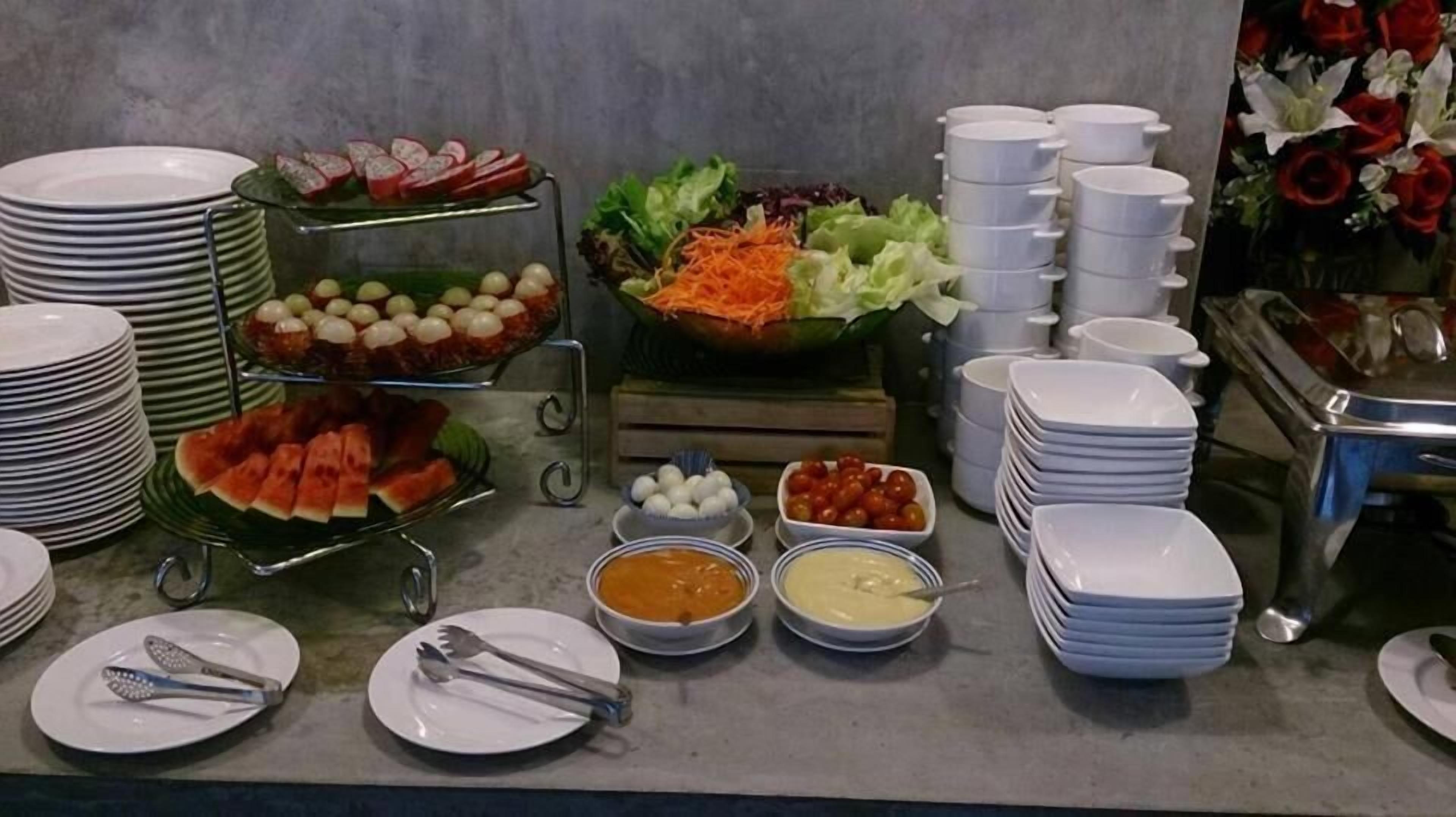 A buffet setup with various food items and utensils.