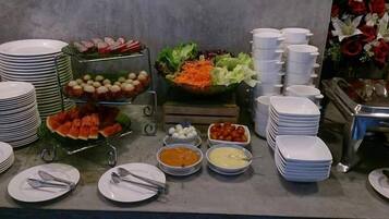 A buffet setup with various food items and utensils.