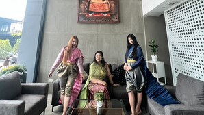 A modern interior with a large window, a painting of a figure, and three people sitting on a sofa. - WE GRAND EVER 9 (Nakhon Ratchasima)