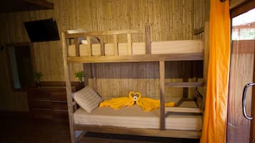 Ein Stockbett mit Holzrahmen, ein an der Wand befestigter Fernseher und ein Fenster mit orangefarbener Vorhang.