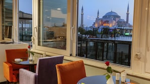 Un espace repas offrant une vue sur un bâtiment historique doté de deux minarets.