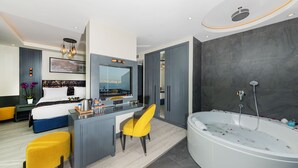 Une chambre d’hôtel moderne dotée d’un grand lit, d’un bureau avec une chaise, d’une salle de bain avec baignoire et offrant une vue sur la ville.