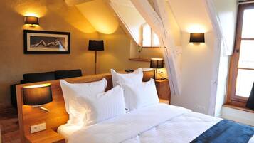 Ein Schlafzimmer mit einem hölzernen Kopfteil, weißer Bettwäsche und zwei Nachttischlampen.