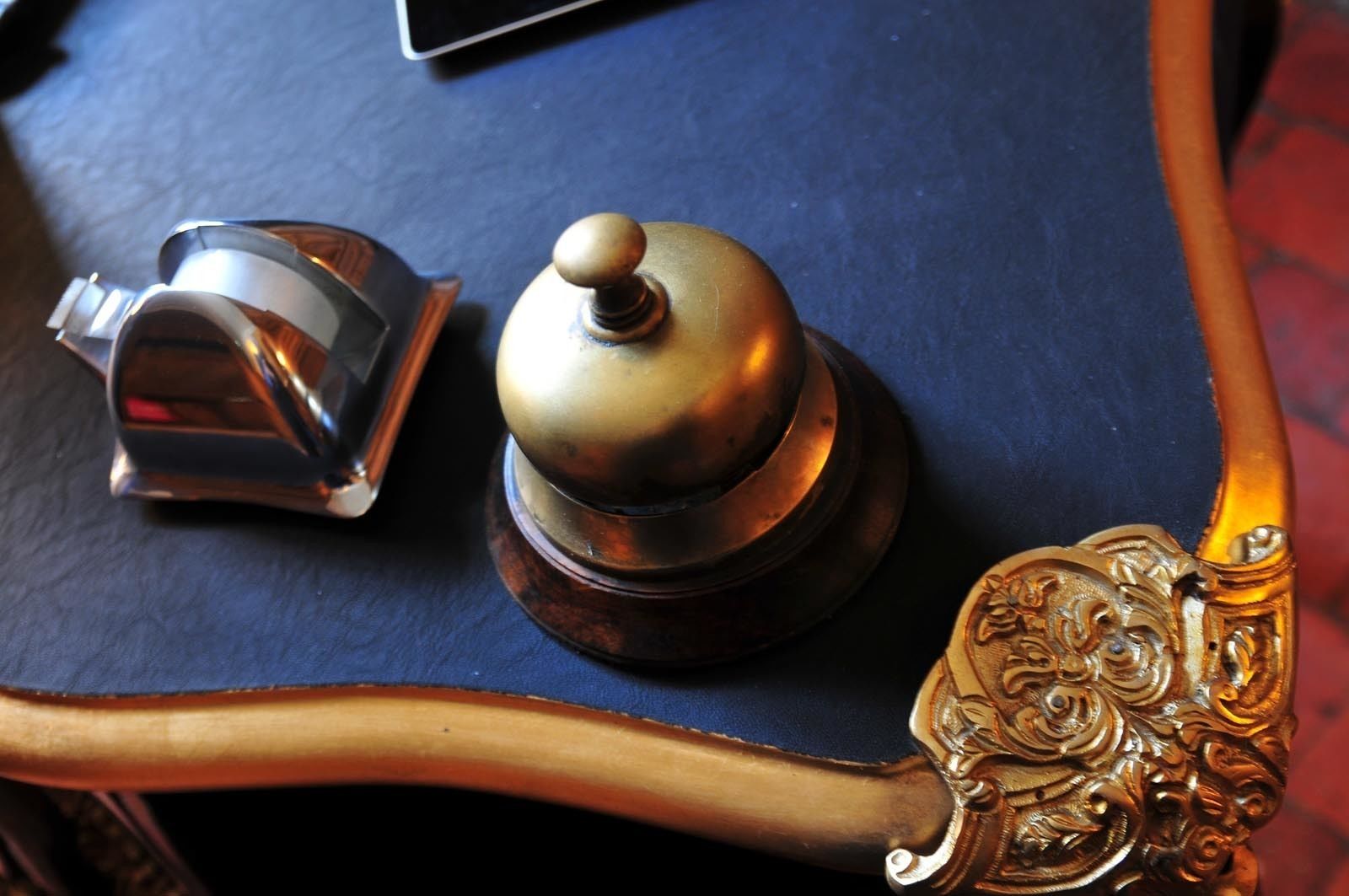 A vintage telephone and a decorative metal object on a blue surface.