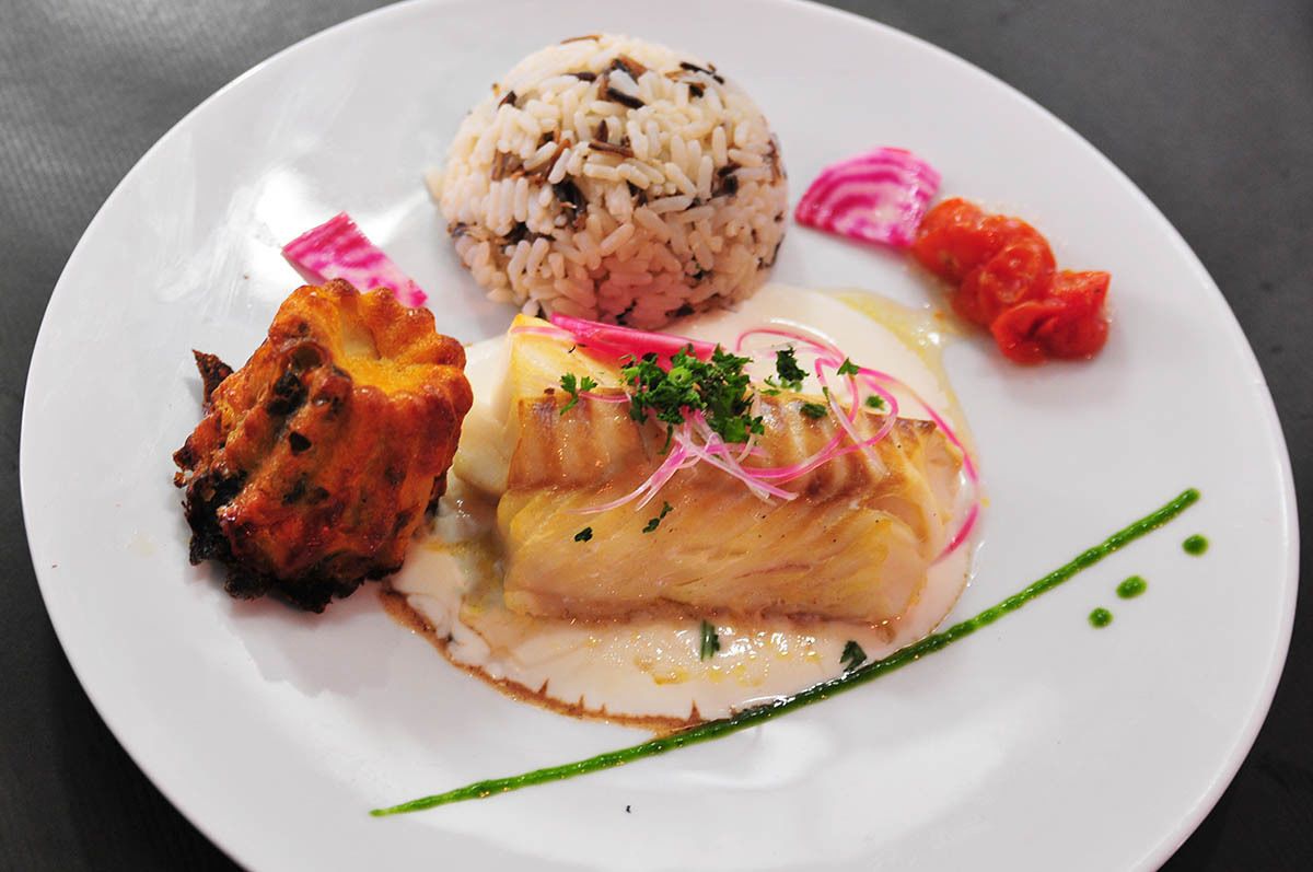 A plate with a piece of fish, rice, and vegetables.