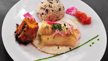 A plate with a piece of fish, rice, and vegetables.