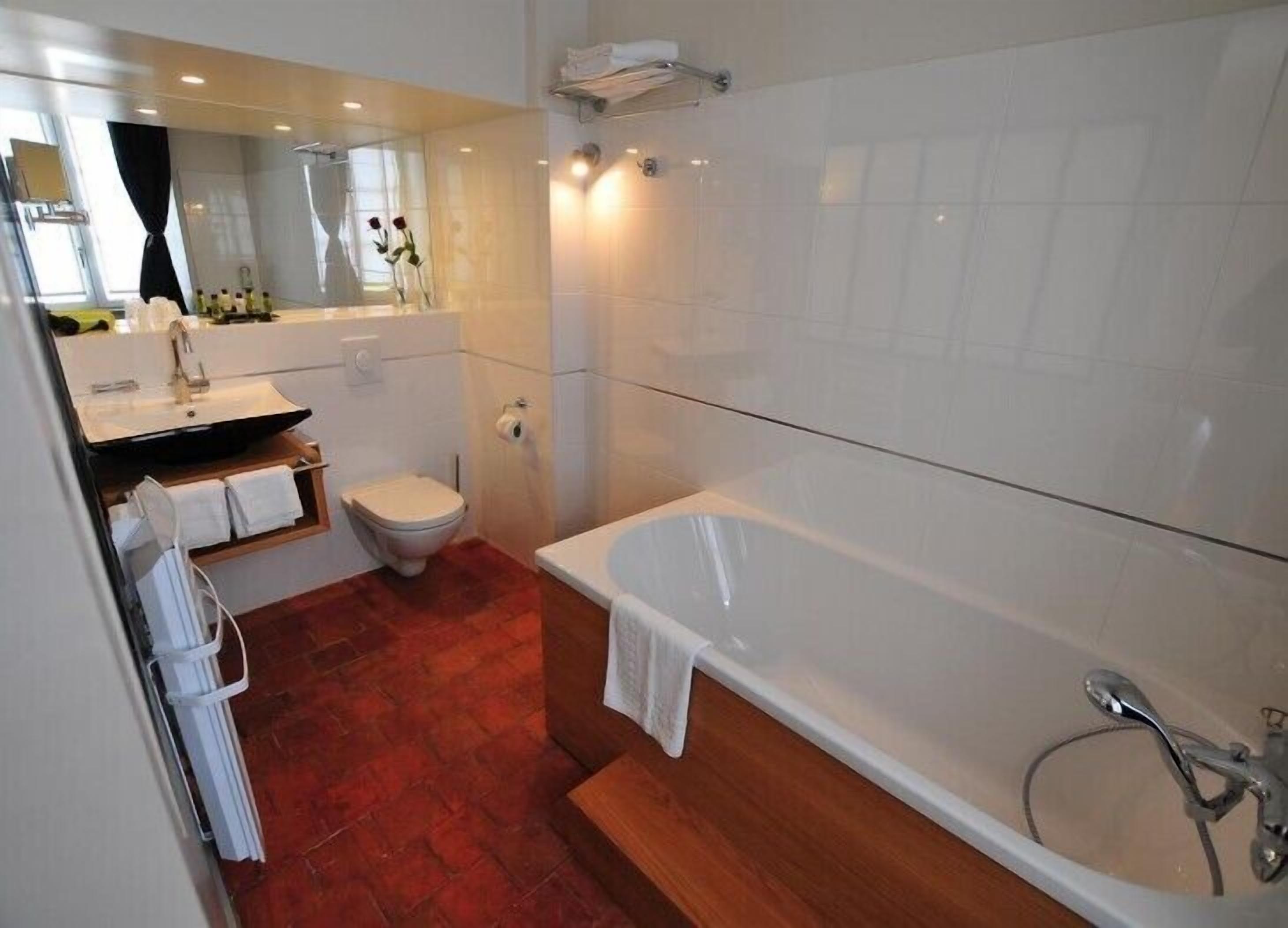 Un baño moderno con bañera, inodoro y lavamanos.