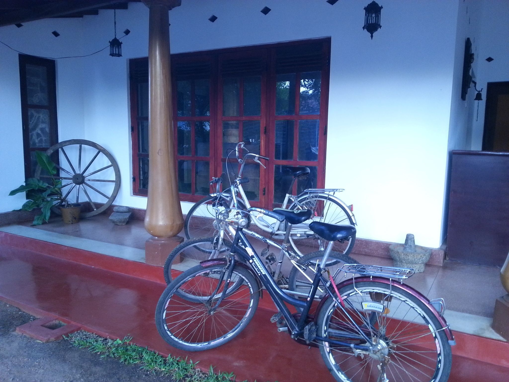 A bicycle parked outside a building with a red door and windows.