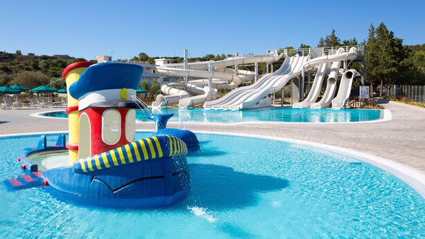 A water park with a large pool, multiple slides, and a colorful play structure. - Cyprotel Faliraki - All Inclusive (Rhodes)