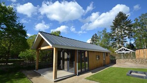 A modern building with a sloped roof, large glass windows, and a wooden exterior. - De Thijmse Berg (Rhenen)
