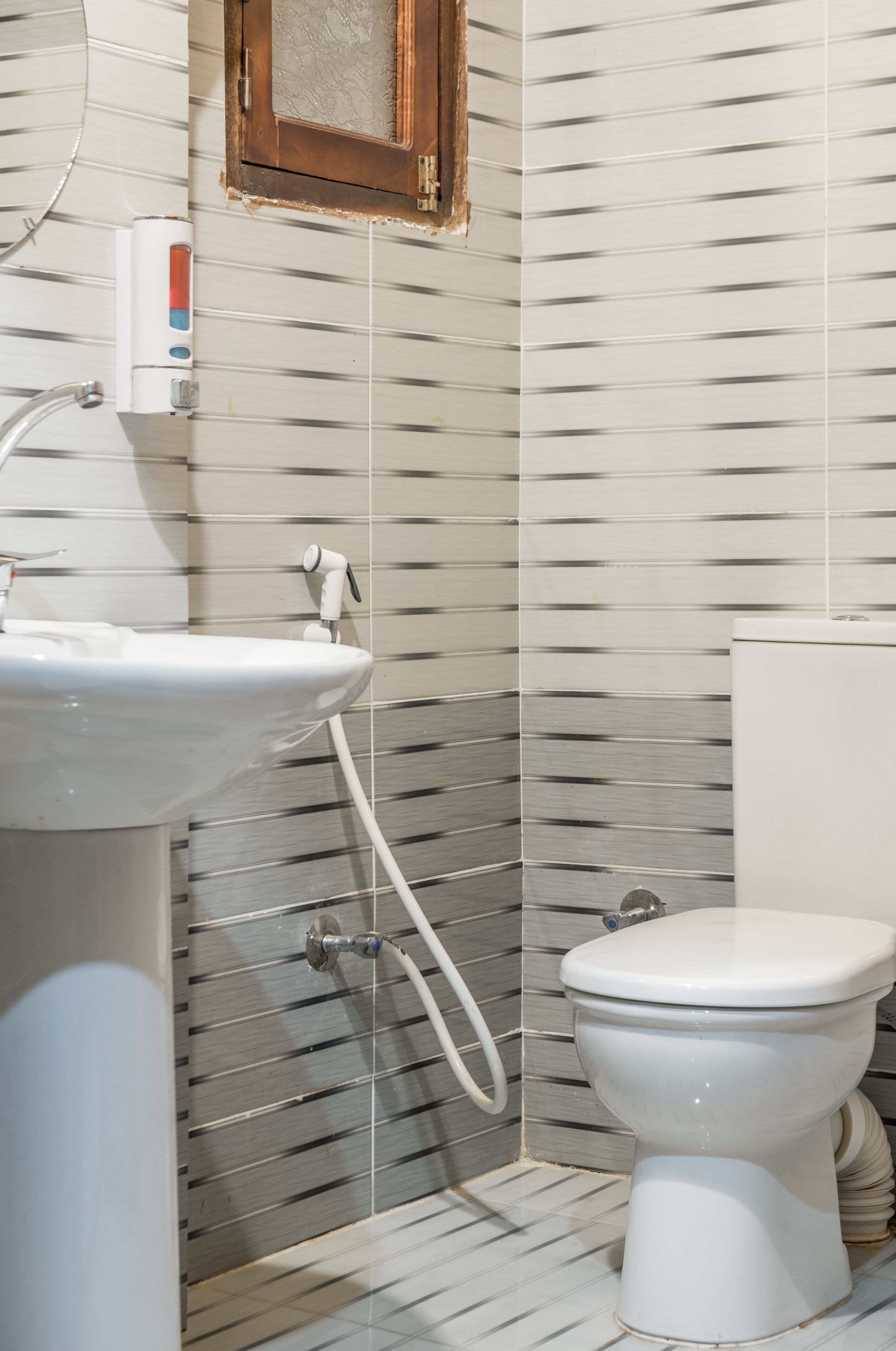 Un baño con lavamanos, inodoro y zona de ducha.