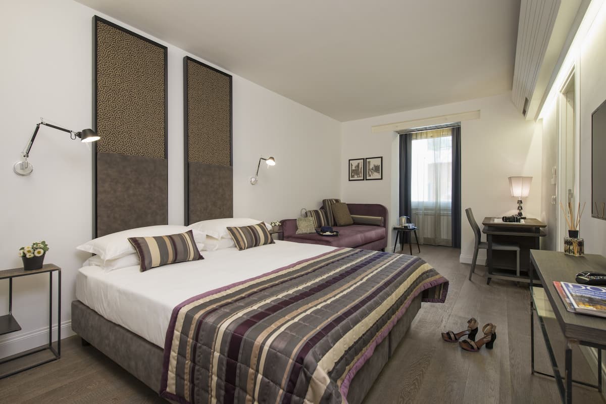 Deluxe kamer | Luxe beddengoed, een minibar, een kluis op de kamer, een bureau
