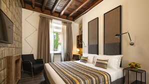 Une chambre d’hôtel avec un grand lit, une chaise, une petite table et un téléviseur.