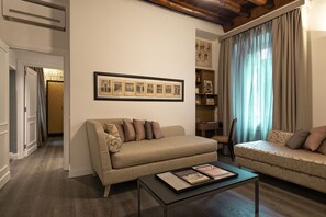 Una sala de estar con un sofá, una mesa de centro y un cuadro en la pared.