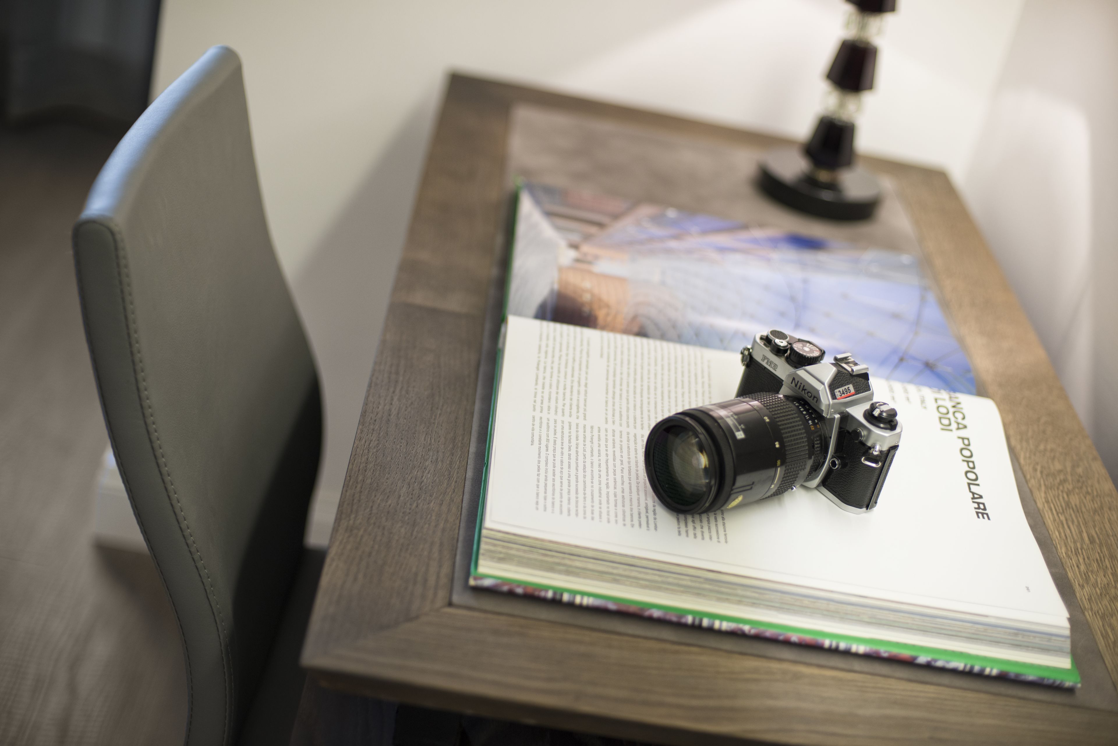 Un appareil photo posé sur un livre intitulé « NINNA POPOLARE », sur une table en bois.